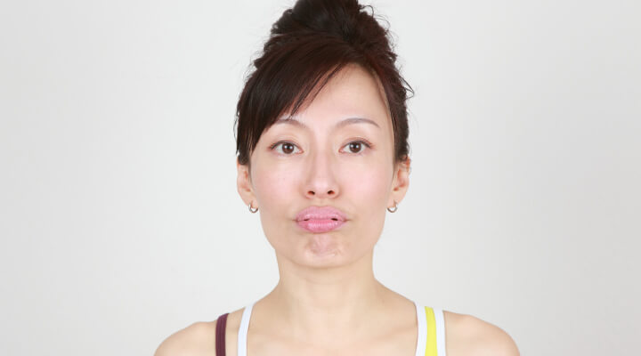 Fumiko Takatsu doing a face yoga exercise while plumping her lips.