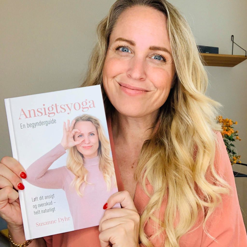 Certified Face Yoga Teacher, Susan Dyhr holding her book, Ansigtsyoga