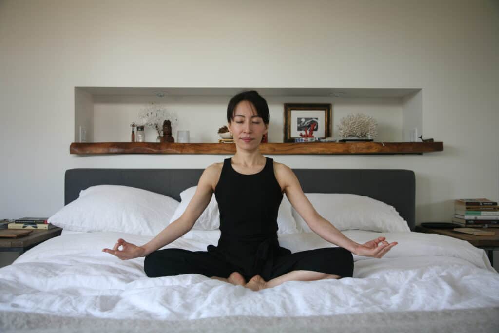 Woman meditating on bed